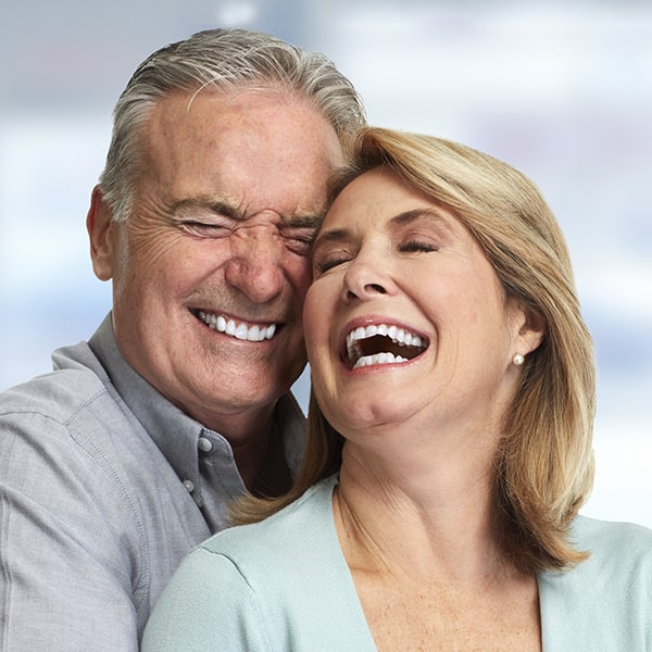 An older couple embracing each other while smiling